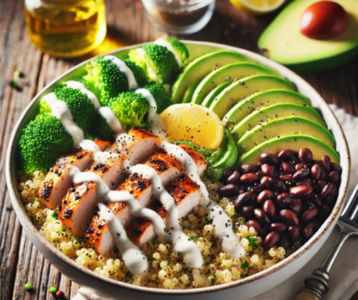 White bowl of Protein-Packed Quinoa & Chicken Bowl Dark wood table, white linen placemat, and silver fork with wood handle. Above, glass jars with gold and clear liquid, edge of a lemon and halved avocado with pit.